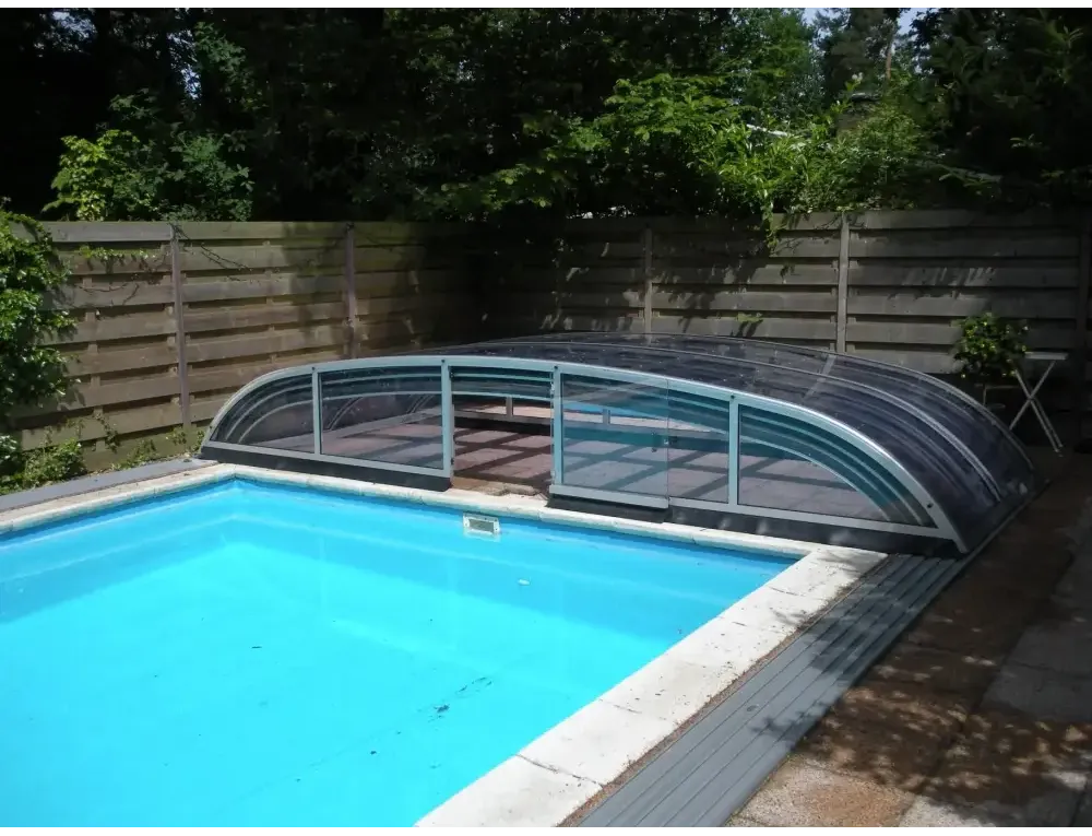 Krökt pooltak Nivo Kit med silverram över blå pool